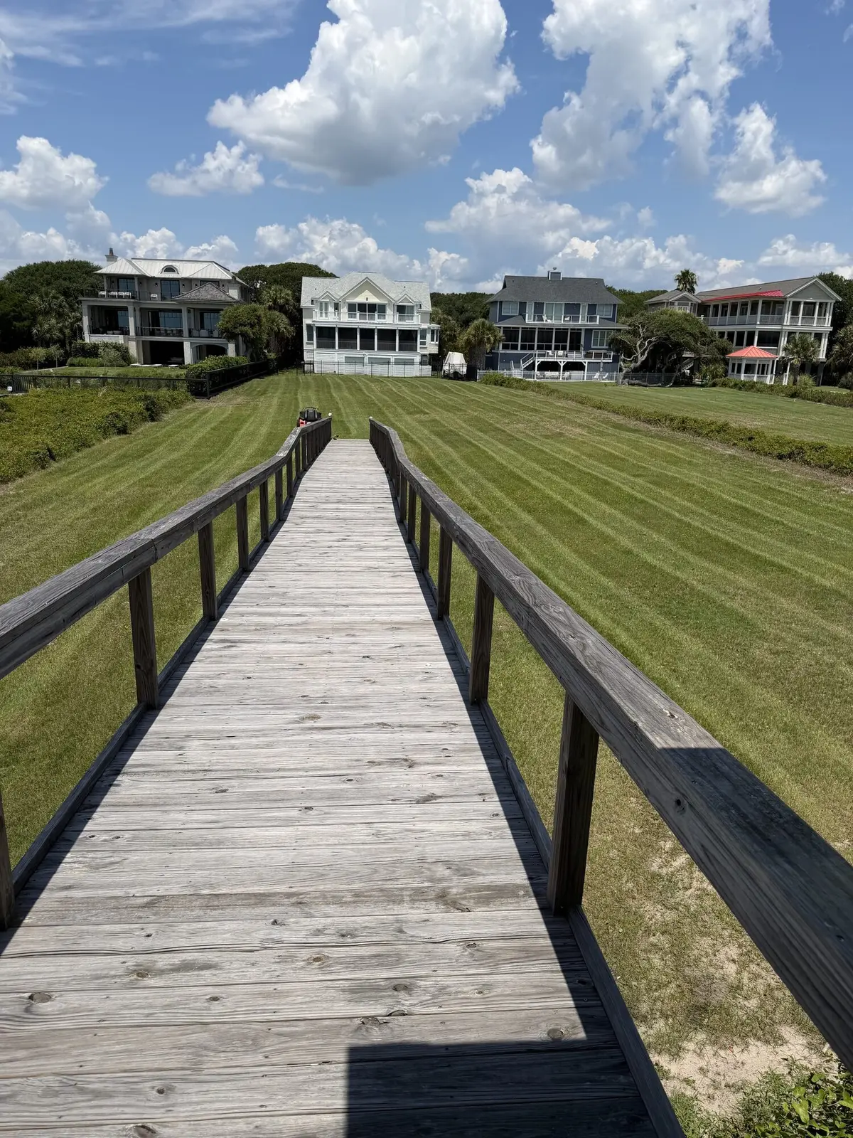 A boardwalk leading across a freshly striped lawn to oceanfront homes on Isle of Palms