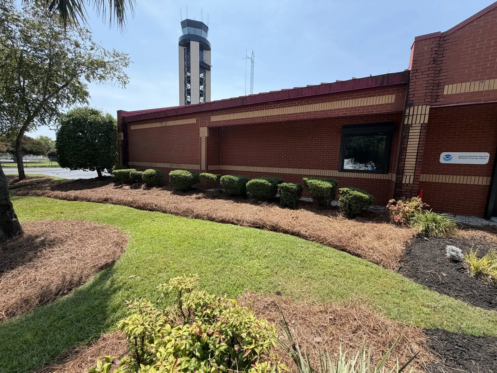 A National Weather Service office building with trimmed shrubs and fresh mulch beds