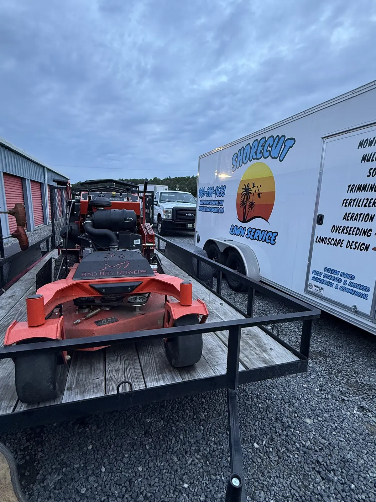 The ShoreCut Lawn Service branded trailer with a full list of services and a Bad Boy zero-turn mower