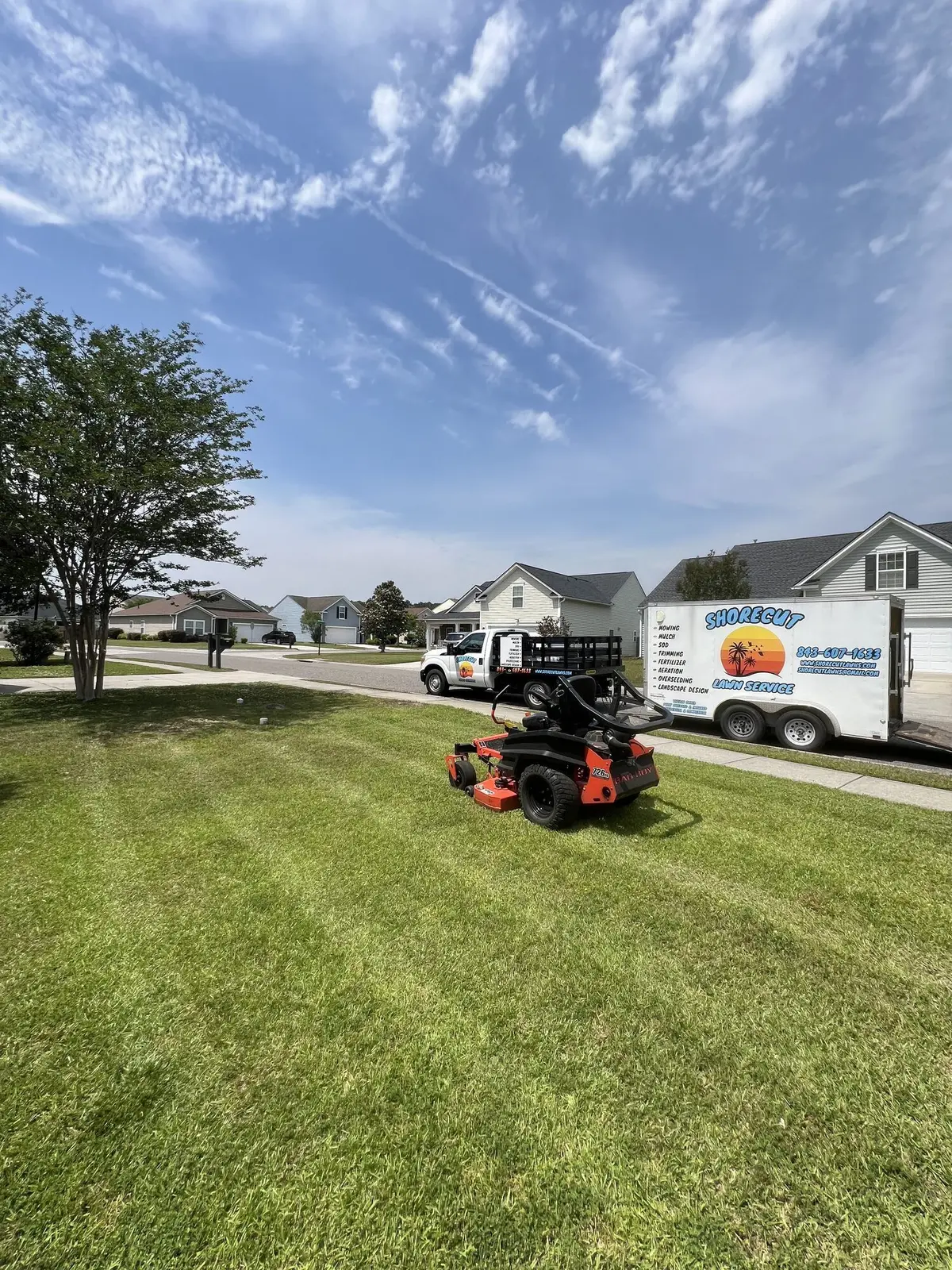 The ShoreCut branded truck and trailer beside a freshly mowed striped lawn